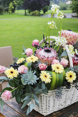 White wicket basket with gerbera and rose flowers