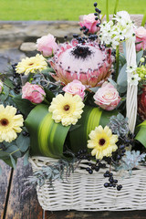 White wicket basket with gerbera and rose flowers