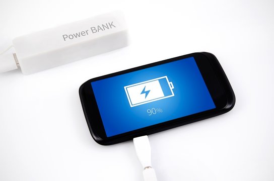 Smart phone charging with power bank on white background