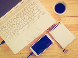 Cup of coffee and laptop on wooden table