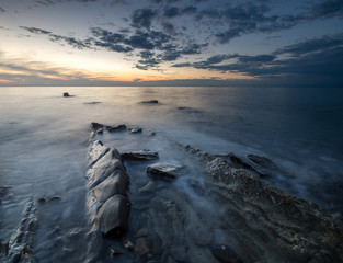 zachód słońca nad skalistą morską plażą © Mike Mareen