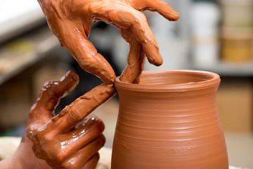hands of a potter, creating an earthen jar