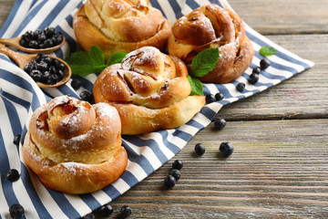 Tasty buns with berries on table close-up