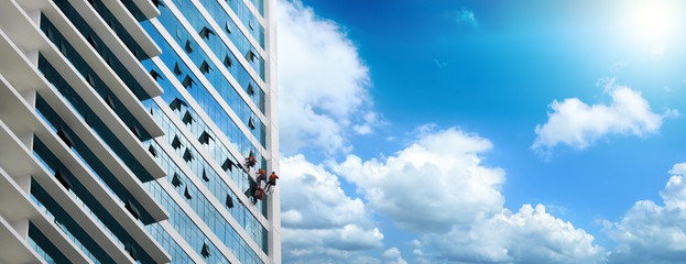 Group of workers cleaning windows on high rise building - obrazy, fototapety, plakaty