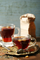 Beautiful vintage composition with herbal tea, on wooden table