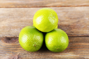 Fresh juicy limes on wooden background