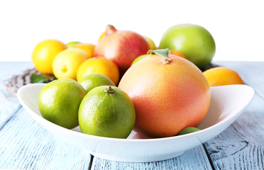 Ripe citrus on plate on wicker background