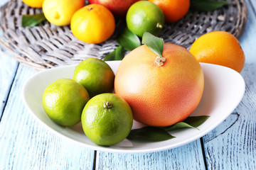Ripe citrus on plate on wicker background