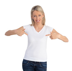 Cheerful woman pointing to her white v-neck shirt