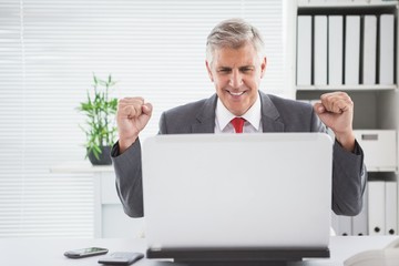Cheering businessman at his desk