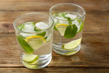 Summer cocktail with ice cubes on wooden table