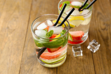 Summer cocktail with ice cubes on wooden table