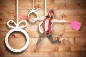 Composite image of happy brunette jumping with gifts bags