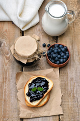Bread with blueberry jam on wooden table