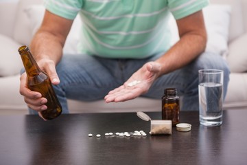 Man mixing beer with his medicine