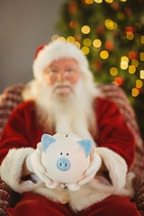 Santa claus offering piggy bank