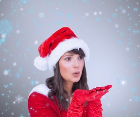 Pretty brunette in santa outfit blowing over hands