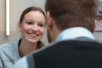 Junge Dame im Gespräch mit Geschäftsmann / entspannt lächelnd