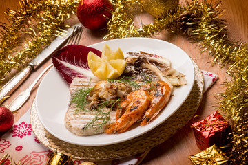 Fototapeta na wymiar mixed grilled fish with red chicory over christmas table