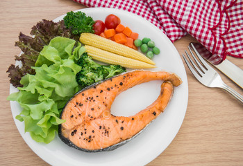 Grilled salmon steak with vegetables on plate