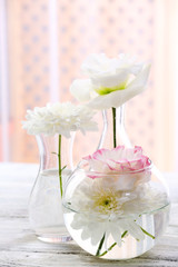 Beautiful flowers in vases with light from window