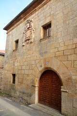 Fototapeta na wymiar casa de piedra con escudo heraldico
