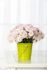 Beautiful bouquet of flowers in bucket on window background