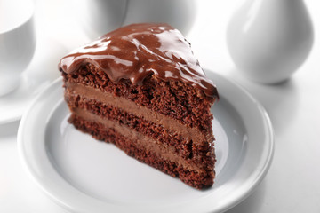 Delicious chocolate cake on plate on table on light background
