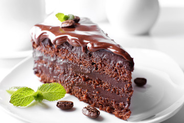 Delicious chocolate cake on plate on table on light background
