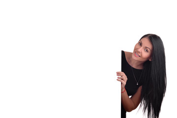 young woman peeking behind empty white billboard
