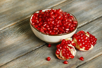 Juicy pomegranate seeds, on old wooden table
