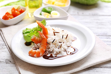 Boiled rice with shrimps served on table, close-up