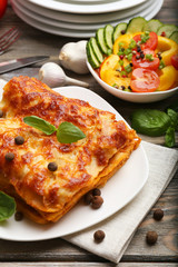 Portion of tasty lasagna on wooden table