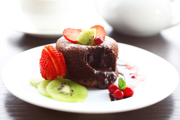Hot chocolate pudding with fondant centre with fruits, close-up