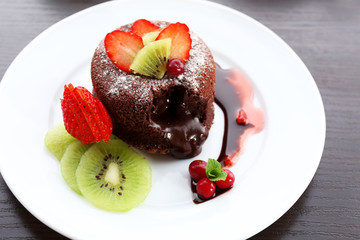 Hot chocolate pudding with fondant centre with fruits, close-up