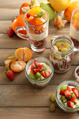 Healthy layered desserts with muesli and fruits on table