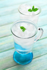 Glasses with ice cubes on wooden table