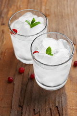 Glass with ice cubes on wooden table