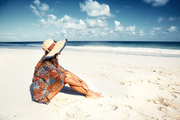 Woman in hat on the beach.
