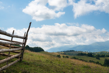 Fototapeta na wymiar Wooden fence against the landscape in the Ukrainian Carpathians