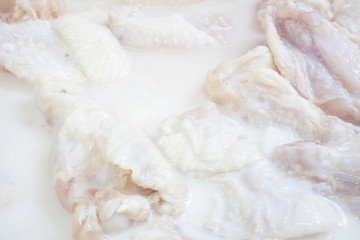 Obraz na płótnie Canvas Raw Chicken Wings marinating in buttermilk