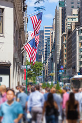Crowded Sidewalk in New York and United States Flags