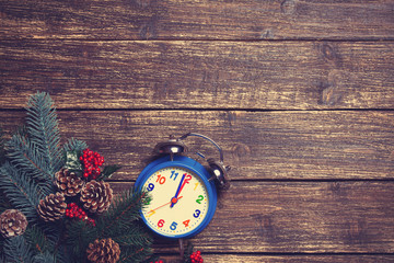 Alarm clock and branch on a wooden table.