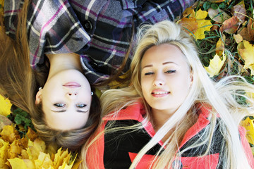 two girls lie on the grass
