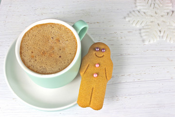 Gingerbread man and coffee Christmas snack on rustic background