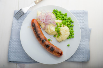 Sausages with mash and some peas and onions