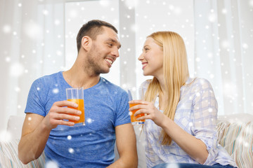 smiling happy couple at home drinking juice