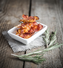 Fried bacon strips with fresh rosemary