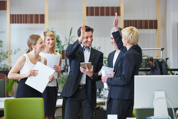 Business Team gibt High Five im Büro