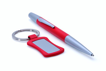 Silver-red metal pen and keychain isolated on white